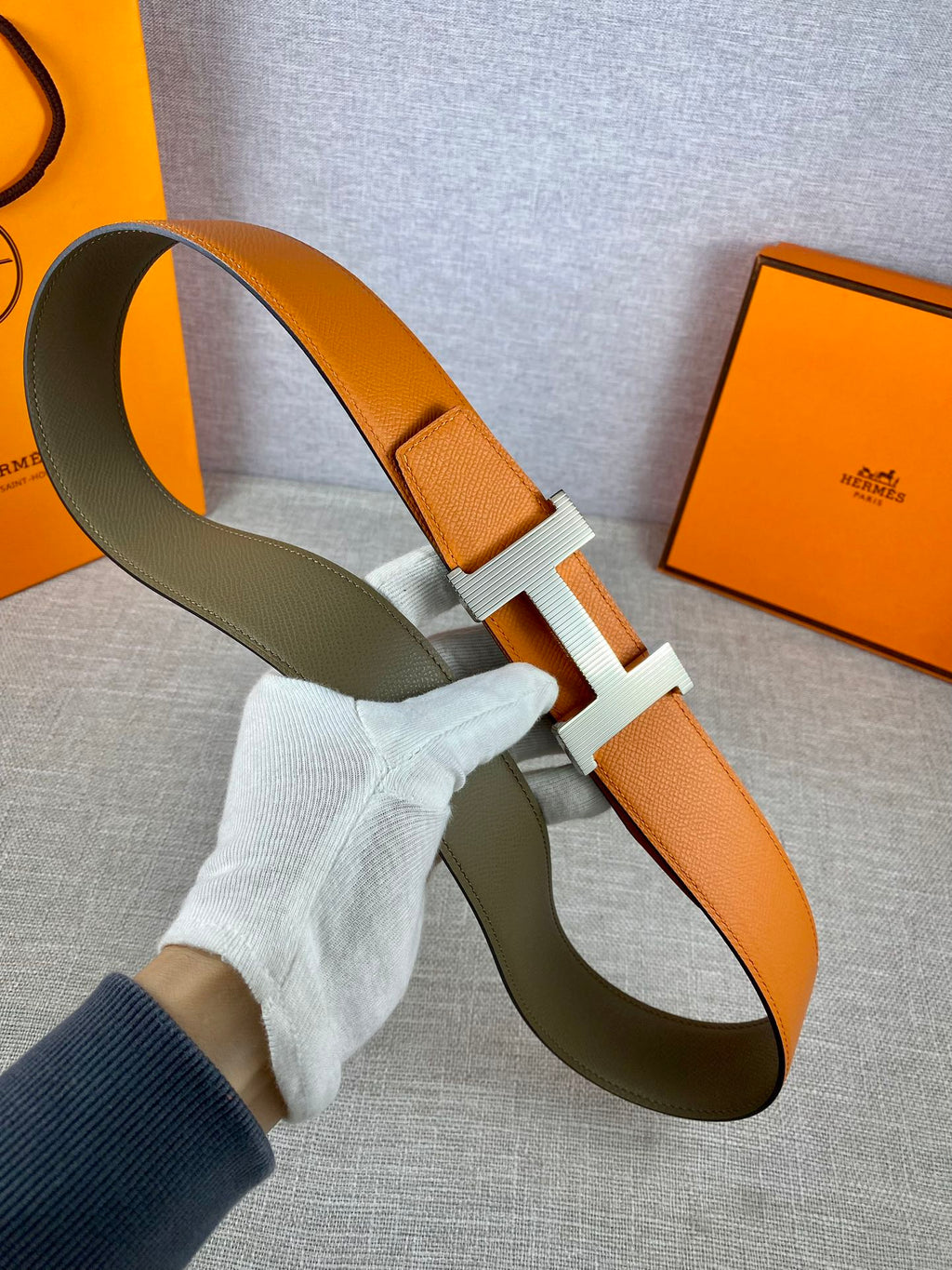 Two-tone leather belt with orange strap and olive strap, ribbed H buckle detail