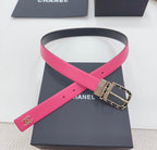 Chanel belt with hot-pink strap detail, navy backing, and gold-tone chain-link buckle.