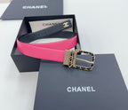 Chanel belt, navy exterior with bright hot-pink inner strap and gold-tone chain buckle.