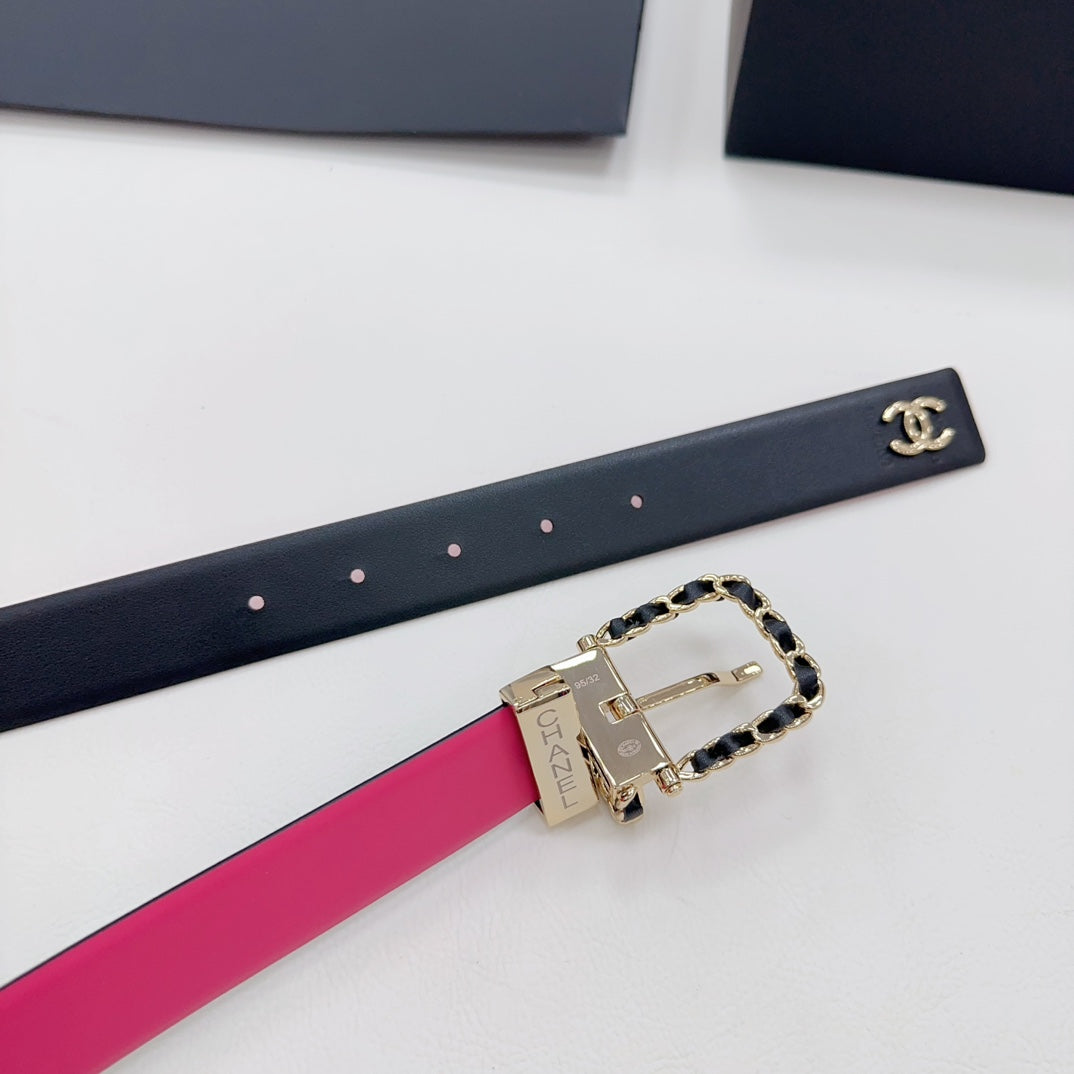 Chanel belt close-up: navy strap with CC logo, hot-pink underside, gold-tone buckle.