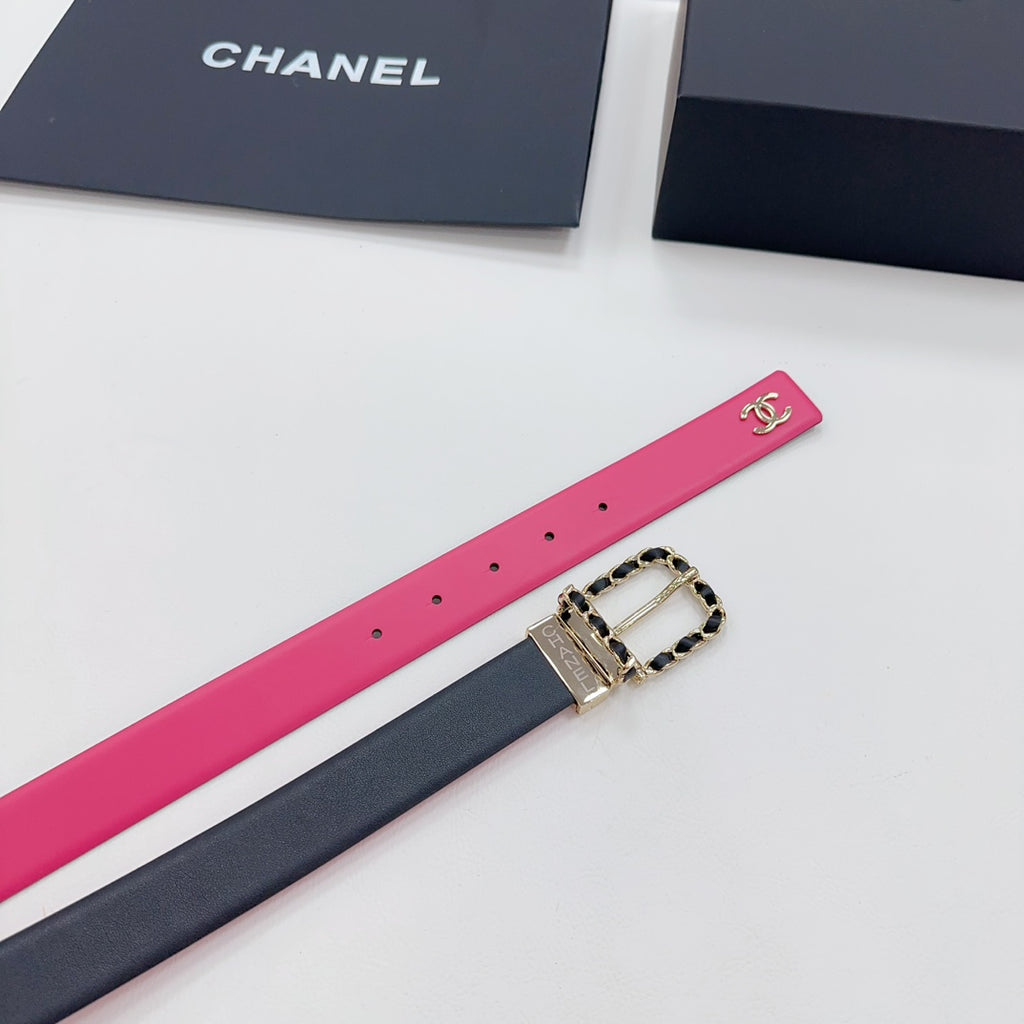 Chanel belt close-up: hot-pink strap with CC logo, navy underside, gold-tone buckle.