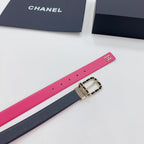Chanel belt close-up: hot-pink strap with CC logo, navy underside, gold-tone buckle.