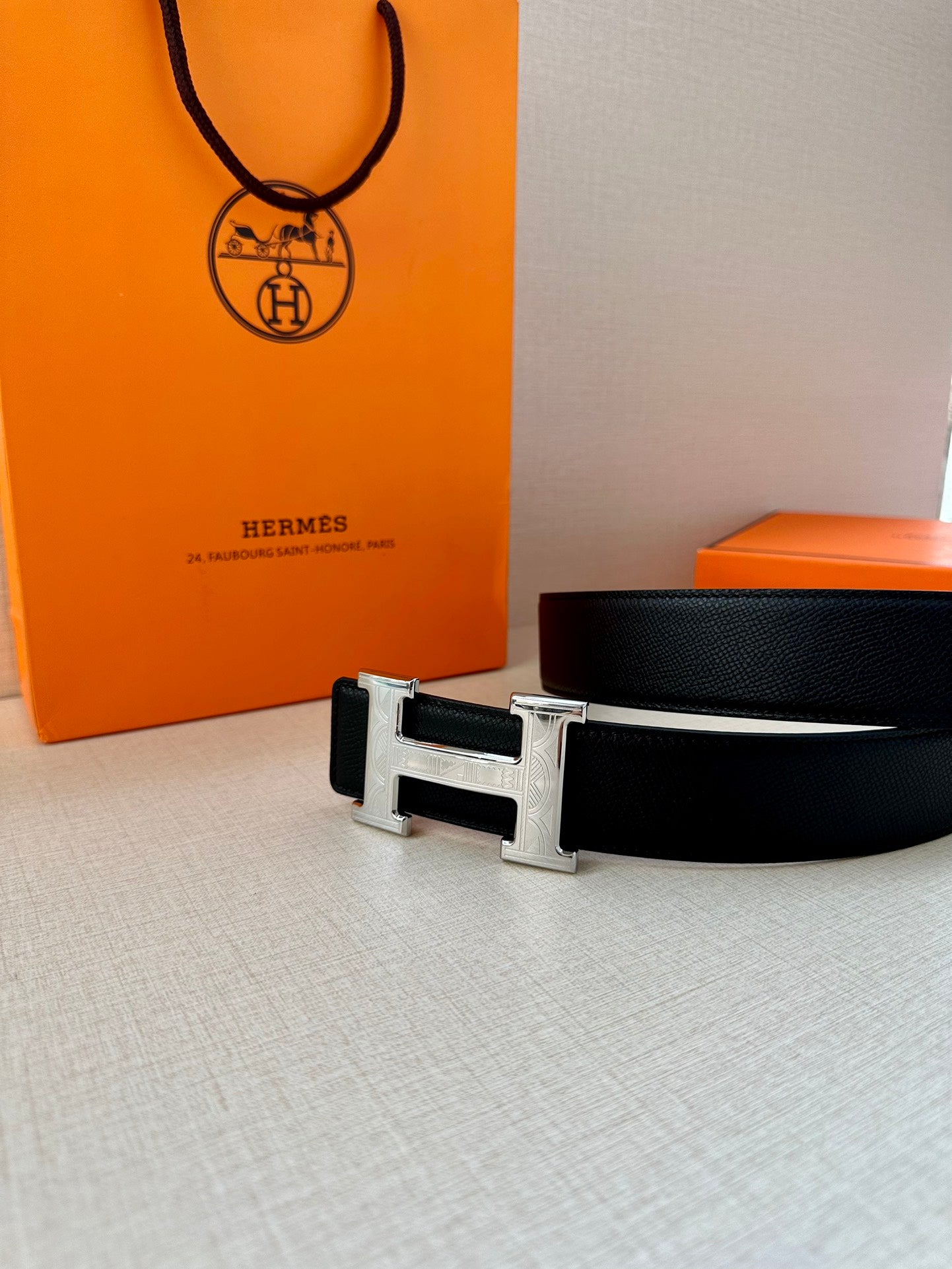 Dark leather belt with metallic rectangular buckle and H motif