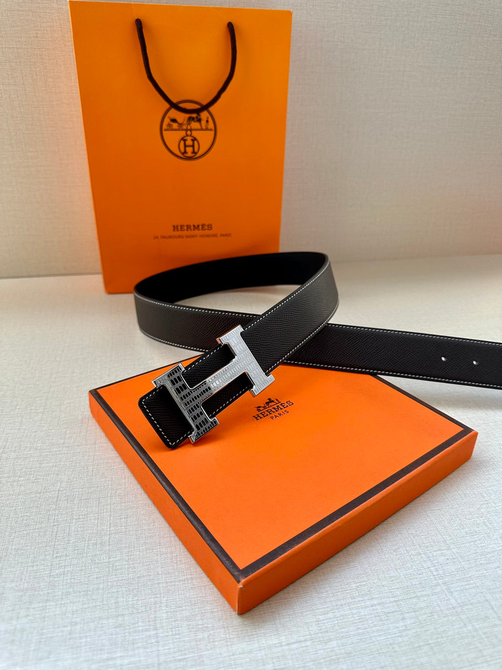 Dark leather belt with silver-tone buckle and textured strap holes
