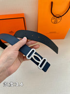 Navy leather belt close-up: silver-tone double buckle