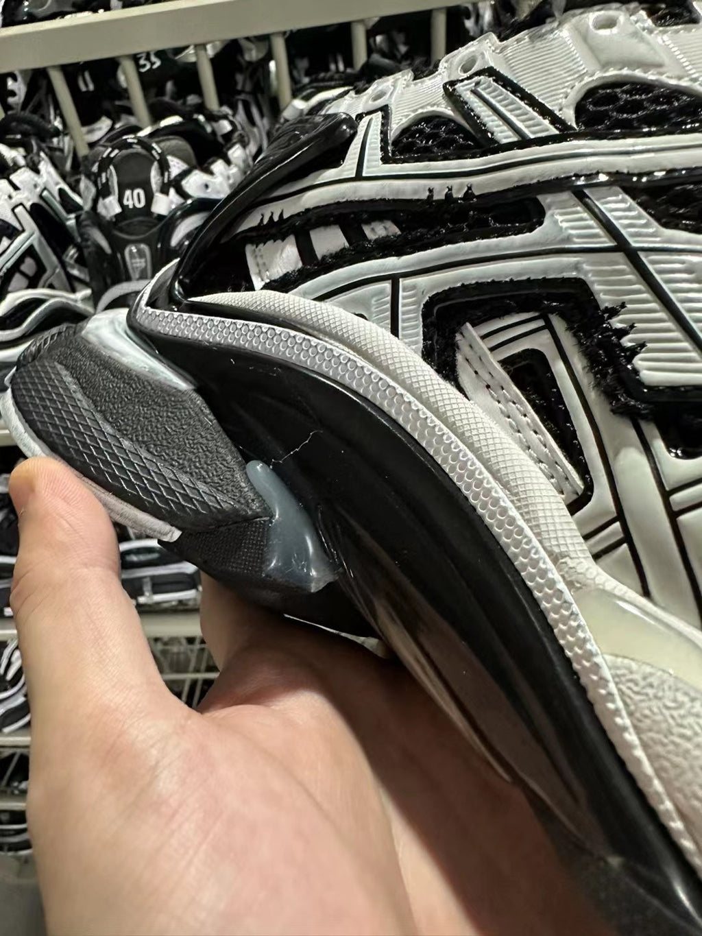 Side view of black and white sneaker with textured upper and padded collar.
