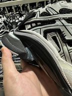 Side view of black and white sneaker with textured upper and padded collar.