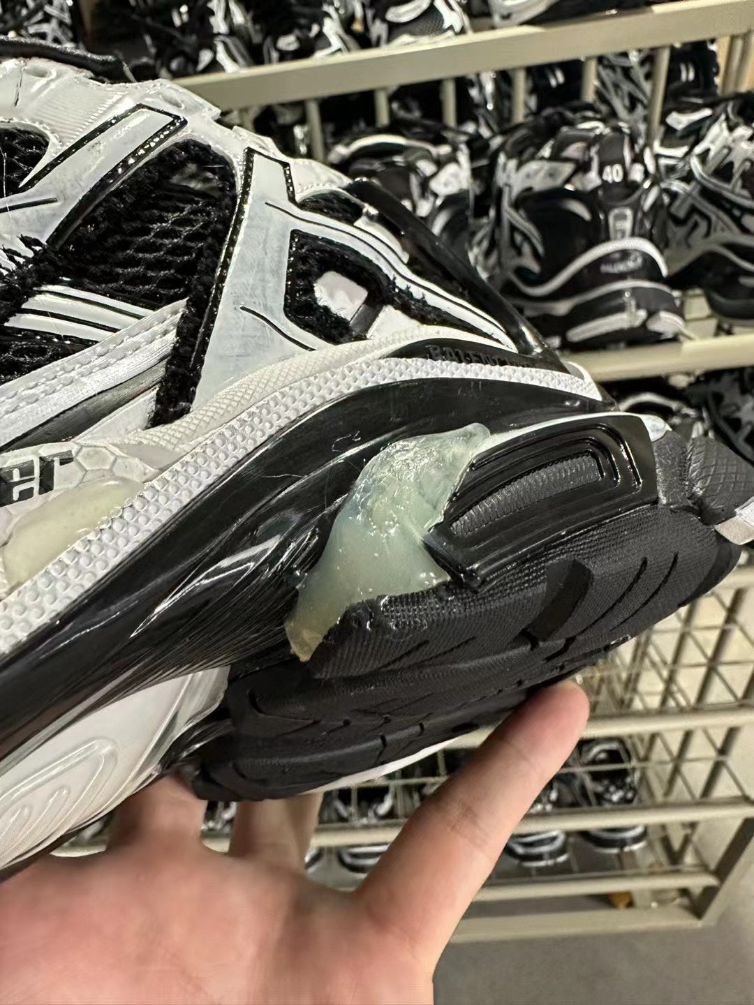 Close-up of sneaker toe and side with black tread sole and white logo trim.