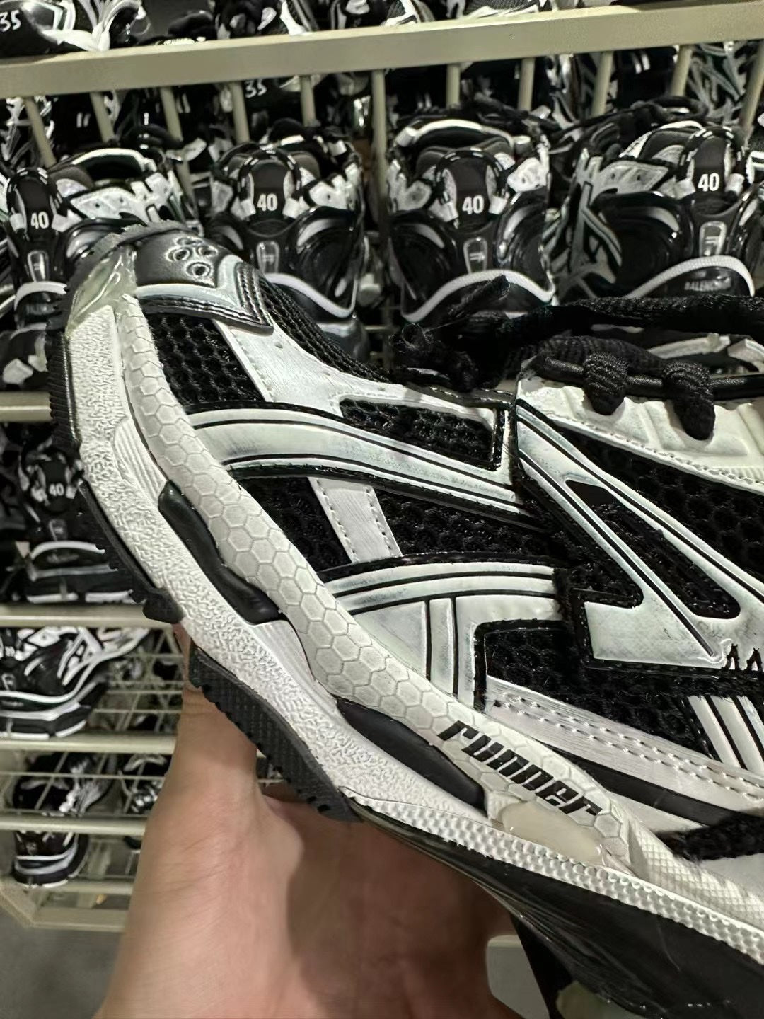 Black and white Balenciaga sneaker with honeycomb textured panels and lace-up front.