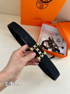 Dark leather belt with gold-tone square link buckle, textured strap and pin closure.