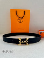 Dark leather belt with gold-tone square geometric buckle, laid flat.