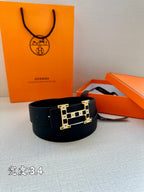 Dark leather belt with rectangular gold-tone buckle featuring geometric enamel blocks.