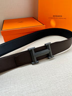 Leather belt with dark pebbled strap and rectangular H buckle; side view