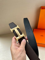 Leather belt with pebbled dark strap and gold-tone H buckle with prong
