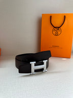 Hermes belt with black leather strap and silver-tone buckle on display
