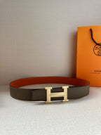 Hermes belt with gray strap and silver H buckle, lying flat on surface