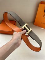 Hermes belt with gray strap and silver buckle, shown from above with orange side