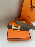 Hermes belt with gray strap, silver buckle, and orange reverse panel