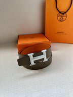 Hermes belt resting with dark strap and silver H buckle, single loop view