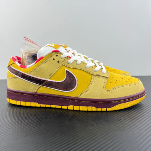 Yellow low-top sneaker with white laces, maroon swoosh, and gum sole.