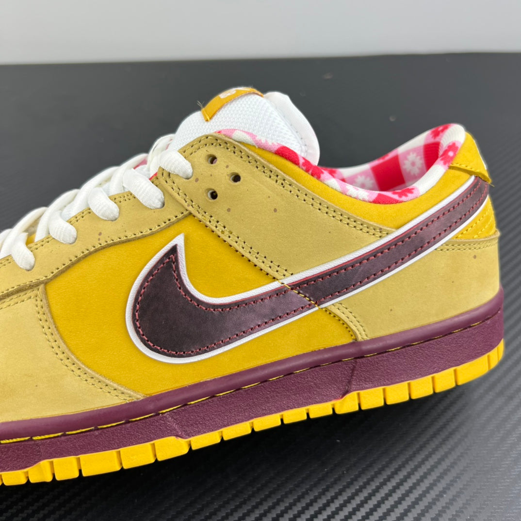Yellow low-top sneaker with maroon swoosh and textured suede panels, white laces.