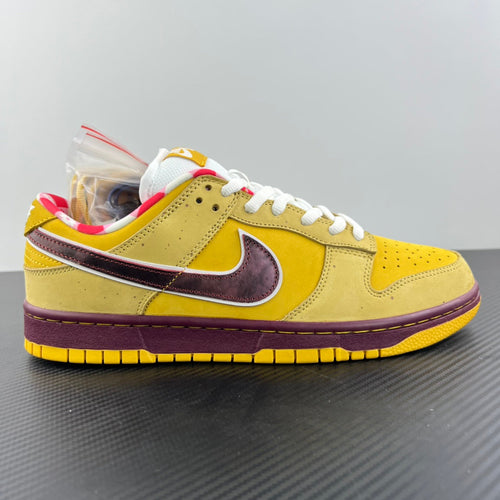 Yellow low-top sneaker with maroon side panel, maroon swoosh, and white laces.