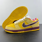Yellow sneaker outsole with circular tread, white laces, and maroon trim.