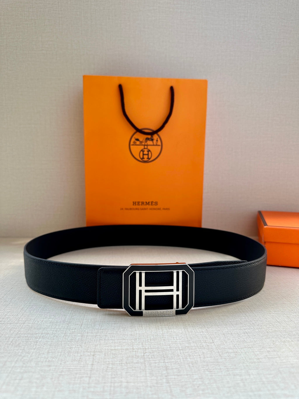 Hermes belt with dark leather strap and silver square buckle, centered with boxes