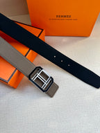 Gray leather belt with square silver buckle, laid flat on the surface