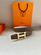 Hermes belt on box: dark taupe leather strap with reversible light gold buckle and keeper