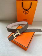 Hermes belt set: taupe leather with cream H buckle and visible white strap.