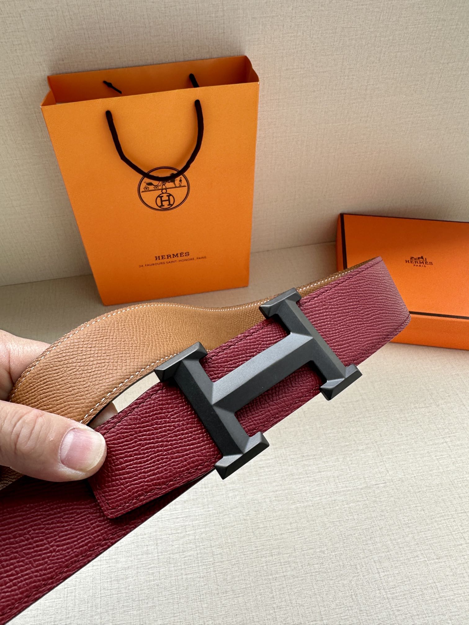 Hermes belt close-up with burgundy leather texture and silver-tone buckle