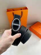 Dark leather belt with oval buckle and metal trim detail