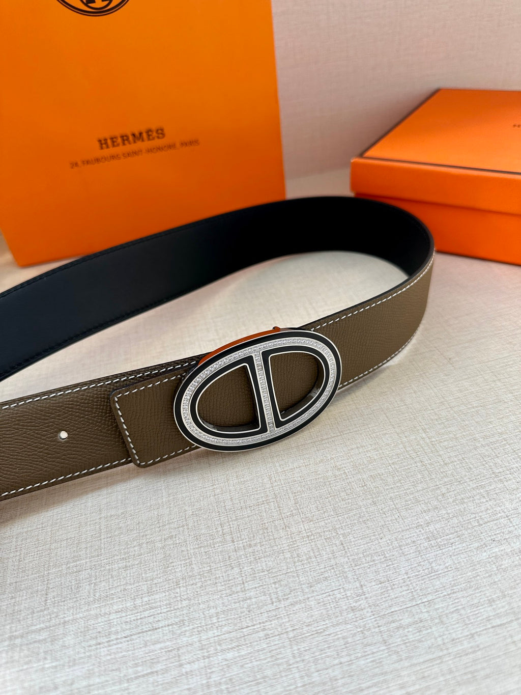 Taupe leather belt with silver-tone oval buckle, side view