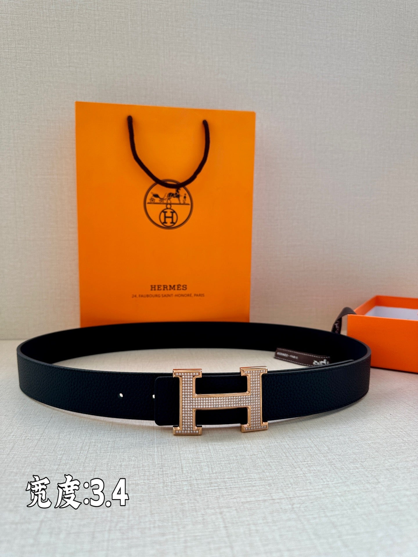 Dark Hermes belt with silver studded H buckle, laid flat