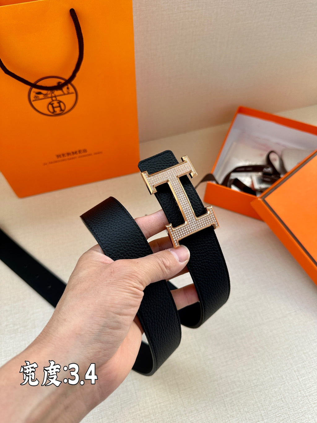 Dark Hermes belt close-up with silver studded H buckle