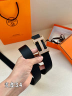 Dark Hermes belt close-up with silver studded H buckle