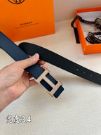 Leather belt, dark blue, silver-tone H buckle close-up with strap end