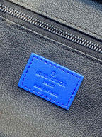 Blue Louis Vuitton embossed label on textured bag material near the zipper