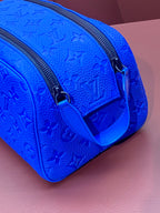 Blue embossed Louis Vuitton zip pouch bag with adjustable strap and metal clasp
