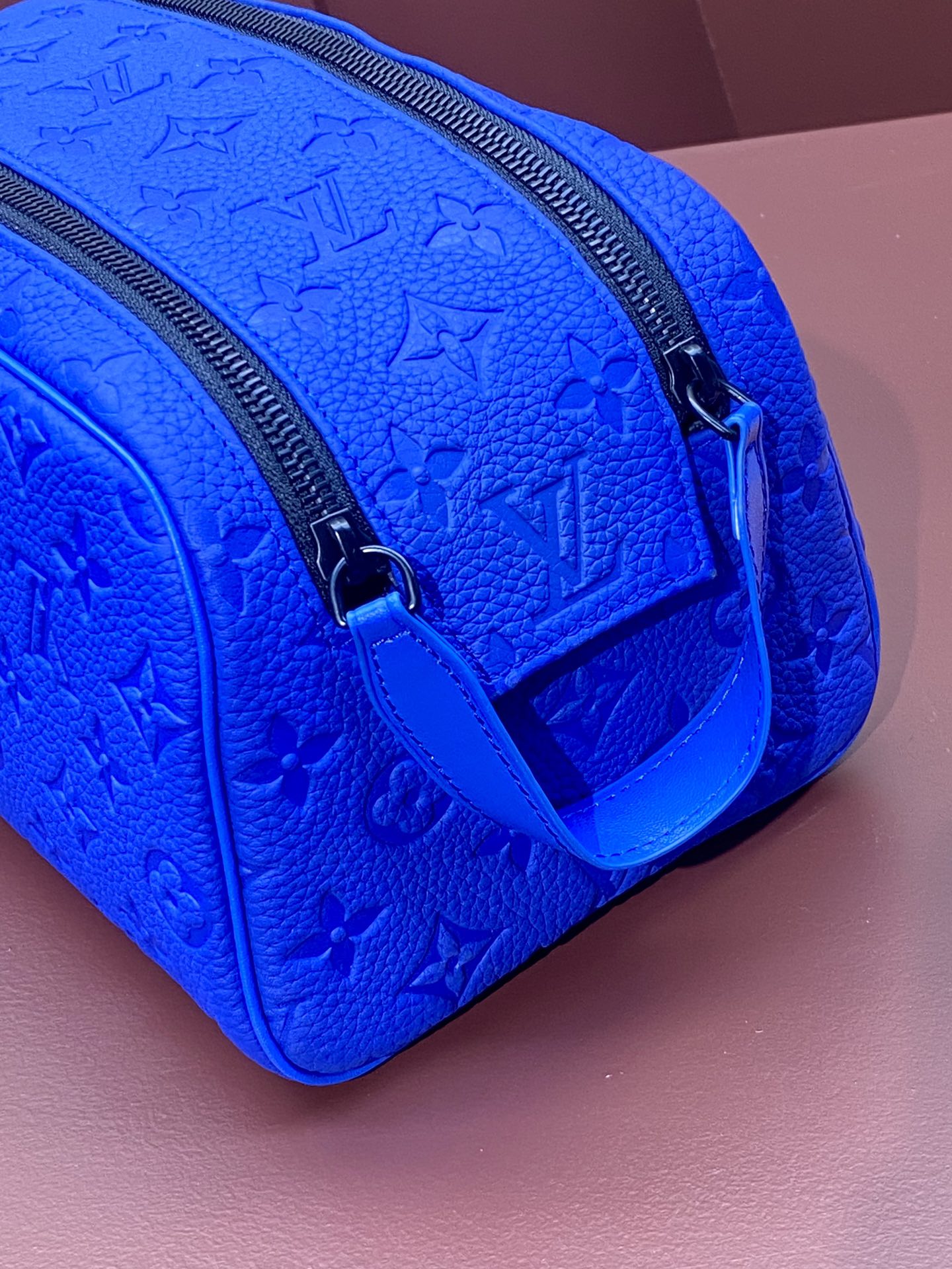 Blue embossed Louis Vuitton zip pouch bag with adjustable strap and metal clasp