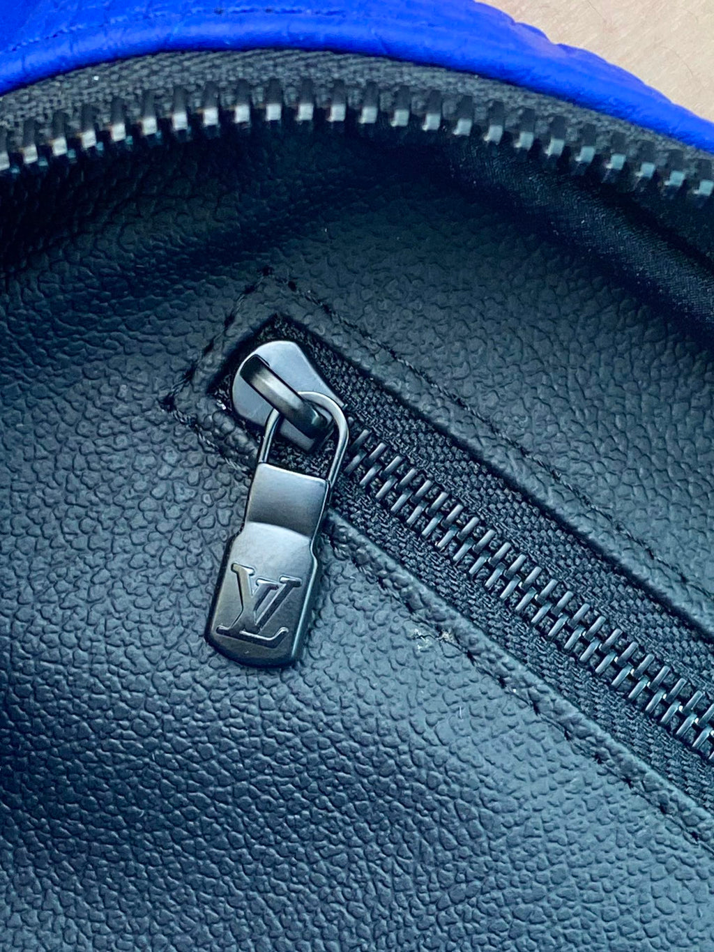 Blue Louis Vuitton zip pouch bag zipper pull on textured leather-look finish