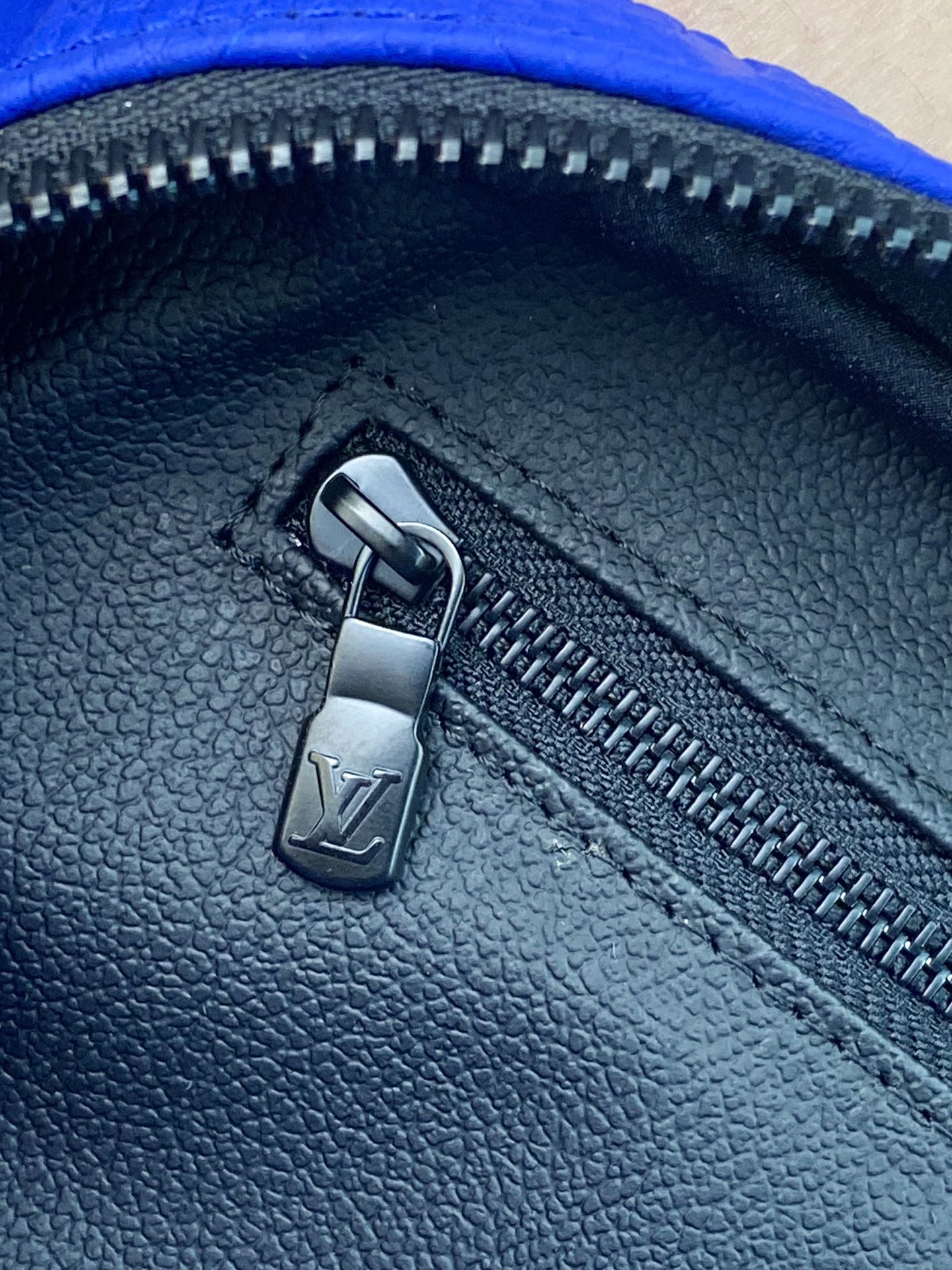 Blue Louis Vuitton zip pouch bag zipper pull on textured leather-look finish