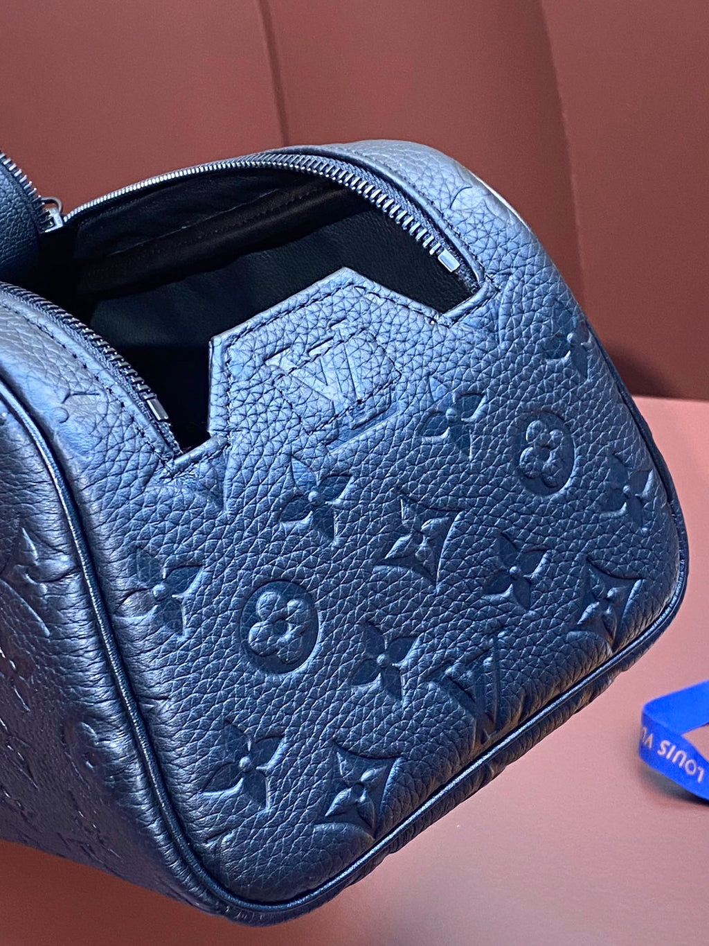 Louis Vuitton blue monogram leather belt bag close-up of embossed pattern on side panel