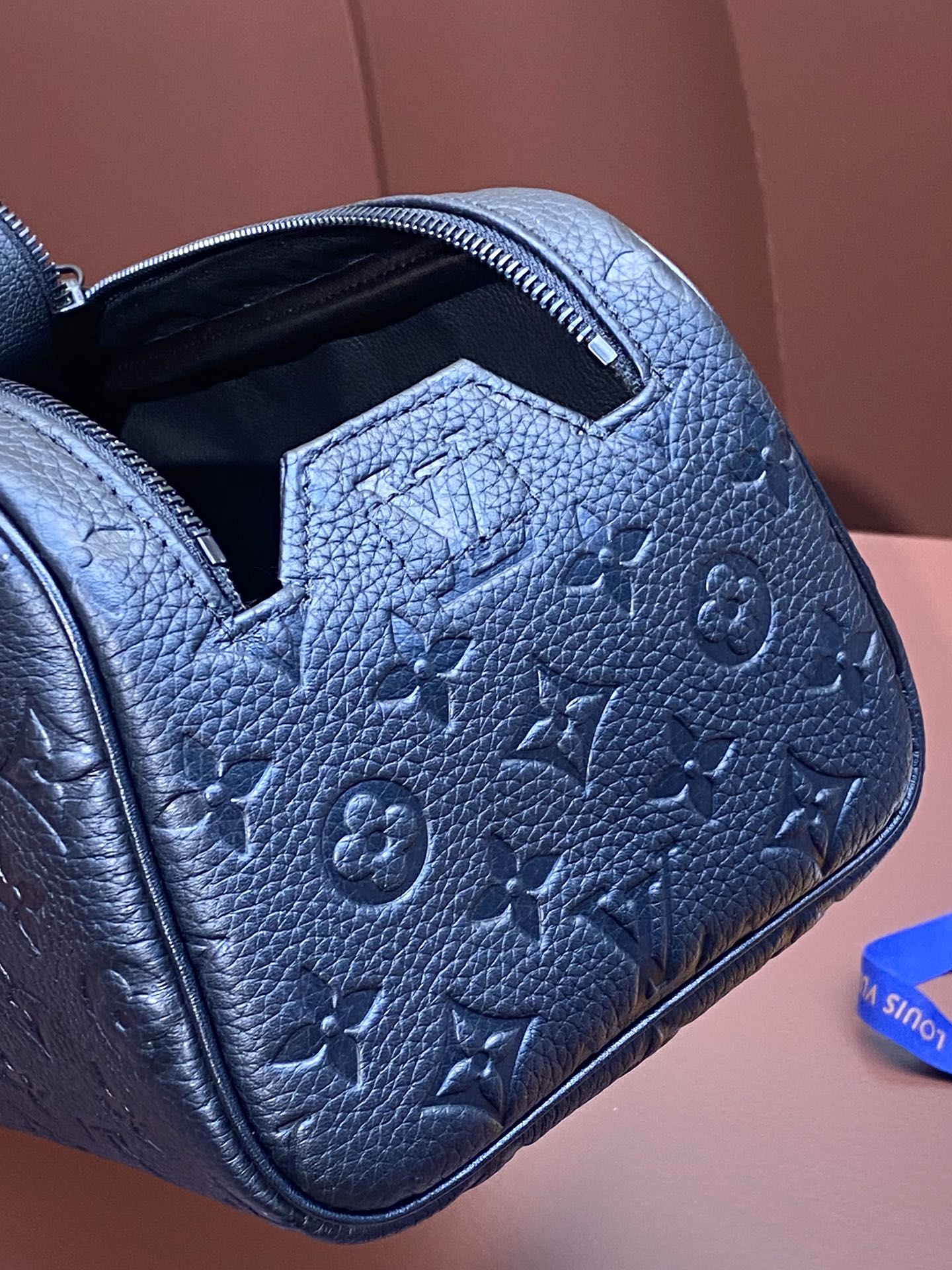 Louis Vuitton blue monogram leather belt bag close-up of embossed pattern on side panel