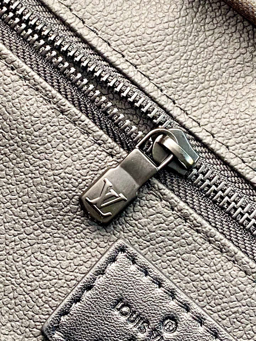 Louis Vuitton blue monogram leather belt bag close-up of metal zipper pull and stitched leather