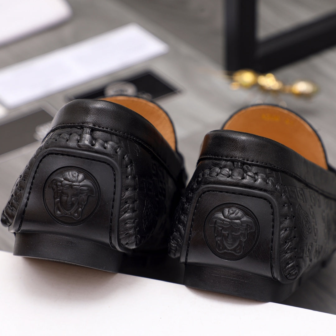 Black leather loafer heel close-up with embossed emblem on back and sides