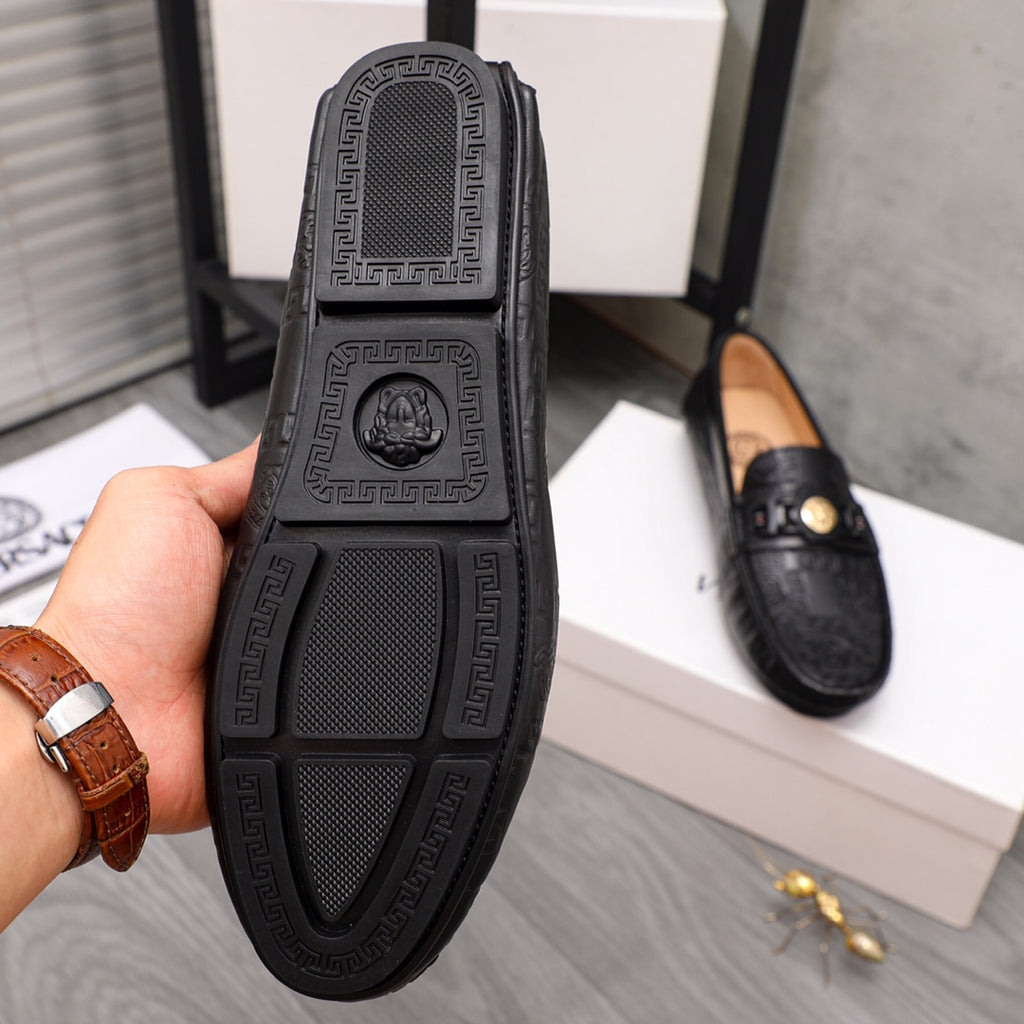 Black leather loafer sole close-up with textured tread and embossed logo border