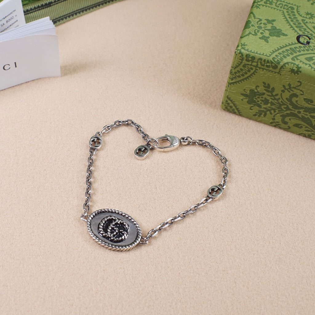 Gucci bracelet with oval logo charm, silver-tone chain and round links
