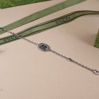 Gucci bracelet with oval logo medallion, silver-tone link chain and clasp